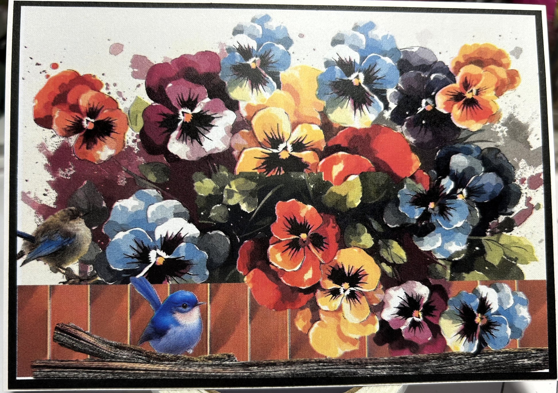 Colourful pansy flowers with birds on a wooden fence